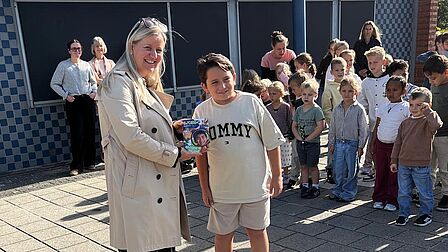  Wethouder Hilde Moerland overhandigt het eerste exemplaar van Sjors Sportief & Creatief aan leerling Mustafa van De Oosterscheldeschool in Scherpenisse
